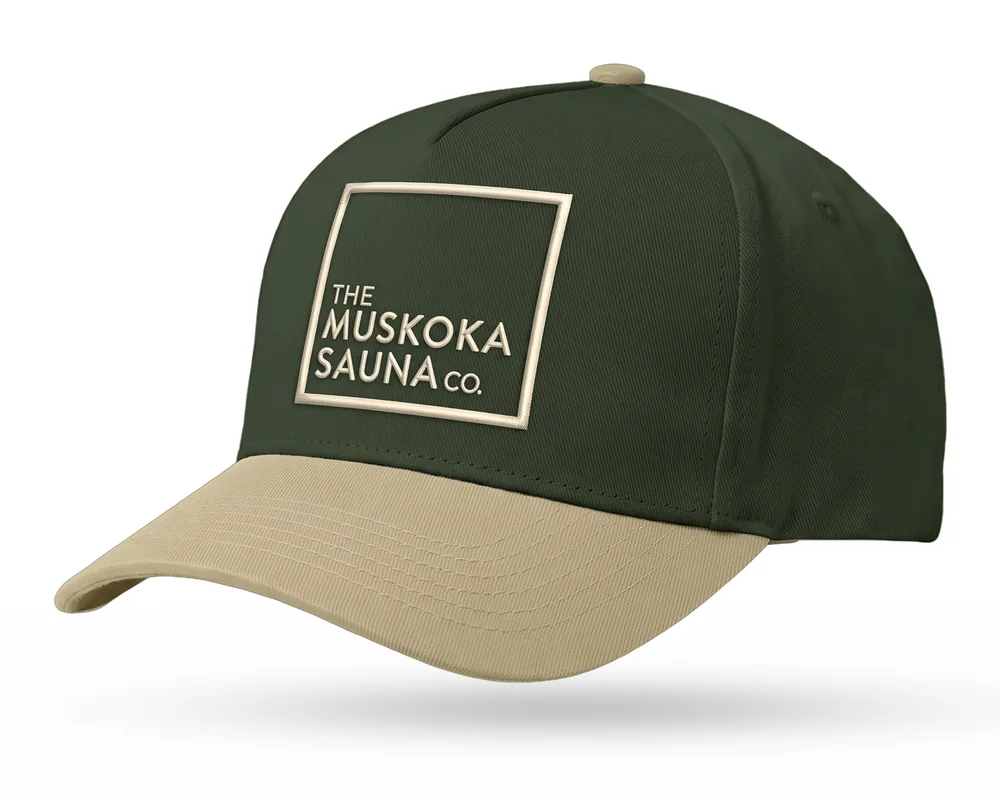 The Muskoka Sauna Co custom 5-panel snapback, forest green crown, sand brim, sand embroidered square logo, the featured hat