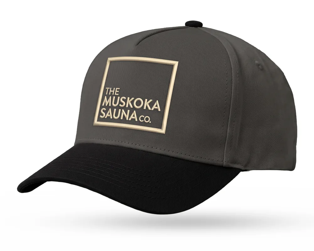 The Muskoka Sauna Co custom 5-panel snapback, charcoal crown, black brim, sand embroidered square logo
